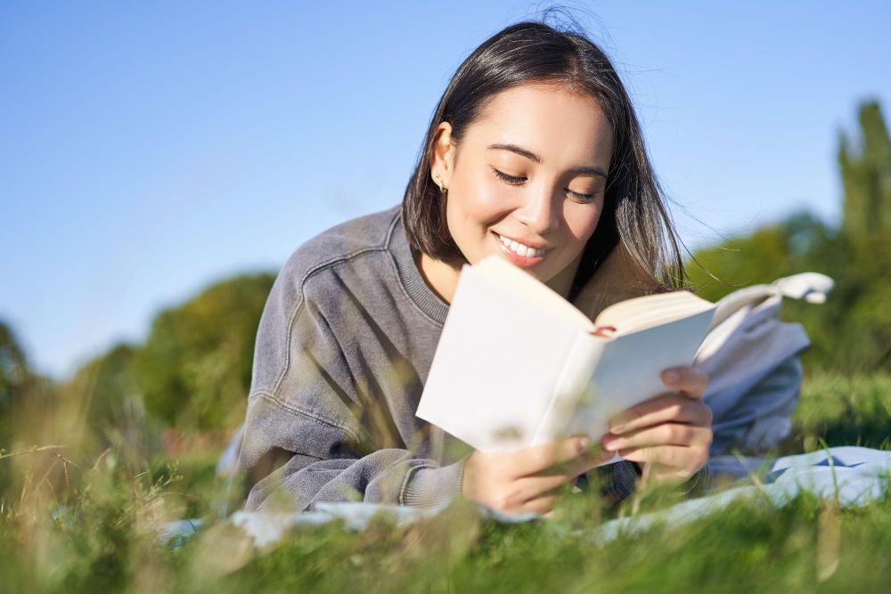 portrait cute korean girl reading park while lying grass relaxing with favorite book han
